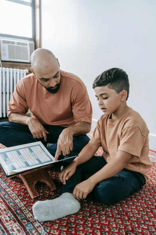 a man and a boy sitting on the floor reading a book, hurufiyya, coding, religious, diagnostics, ios