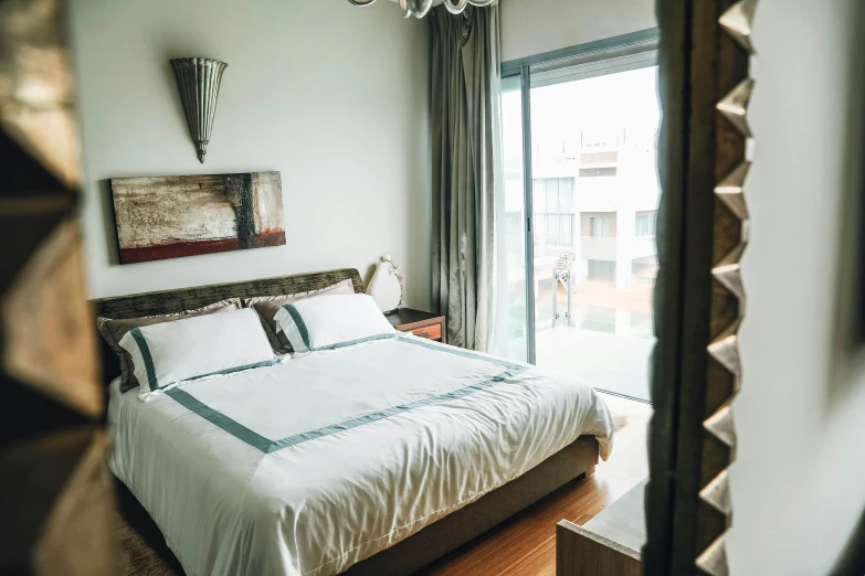 a bed room with a neatly made bed and a chandelier, by Daniel Lieske, unsplash, square, balcony, glazed, moroccan