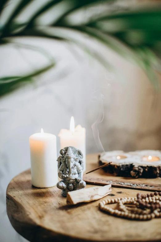 a candle sitting on top of a wooden table, floating symbols and crystals, sage smoke, brightly lit room, botanicals