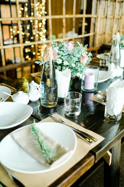 a wooden table topped with white plates and silverware, farms, intricate sparkling atmosphere, brightly lit