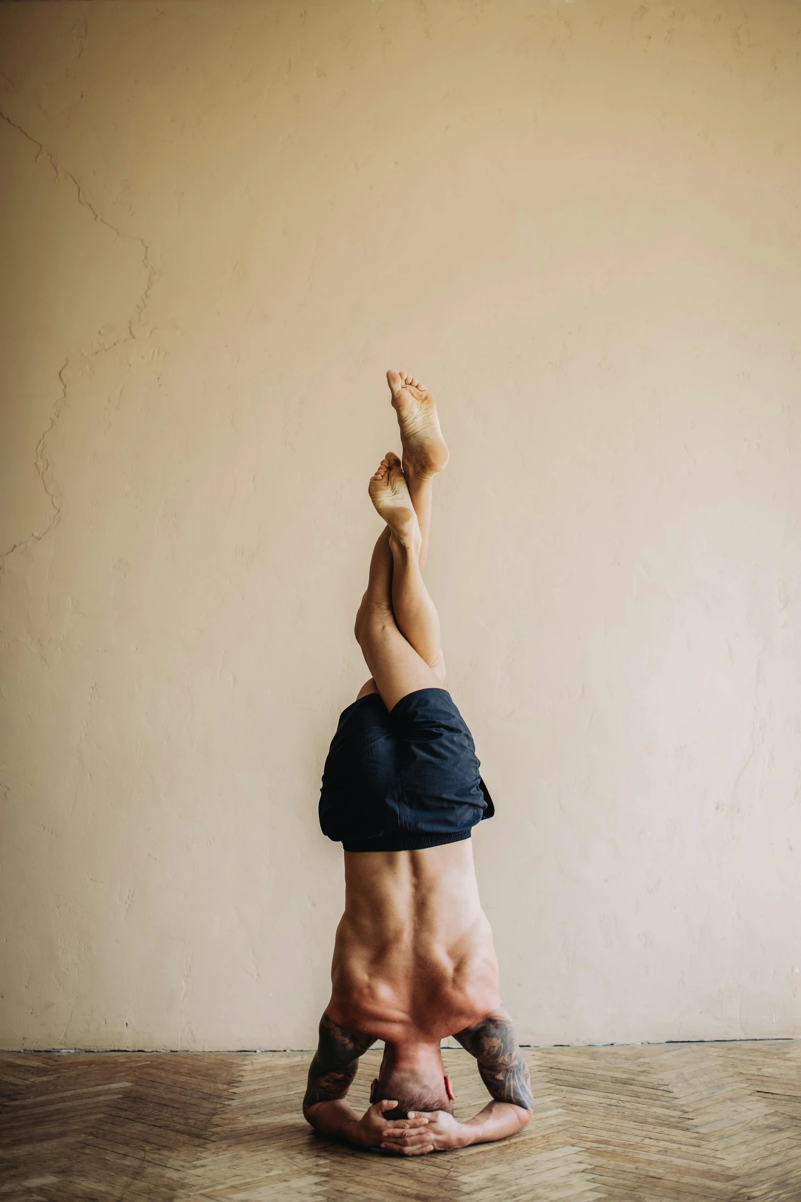 a man doing a handstand on a hard wood floor, a picture, unsplash, arabesque, portrait of tall, of a muscular, with a spine crown, sydney hanson