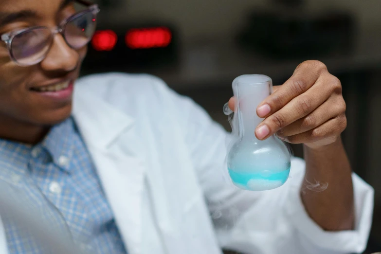 a close up of a person in a lab coat holding a flask, unsplash, blue, avatar image, dry ice, ashteroth