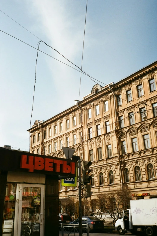 a man riding a skateboard down a street next to tall buildings, inspired by Mikhail Lebedev, unsplash, socialist realism, banners with lenin, wires hanging above street, 1990s photograph, saint petersburg
