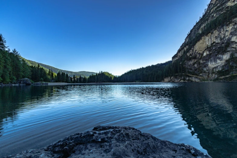 a large body of water surrounded by trees, by Matt Cavotta, pexels contest winner, les nabis, clear blue sky, early evening, mountain lakes, today\'s featured photograph 4k