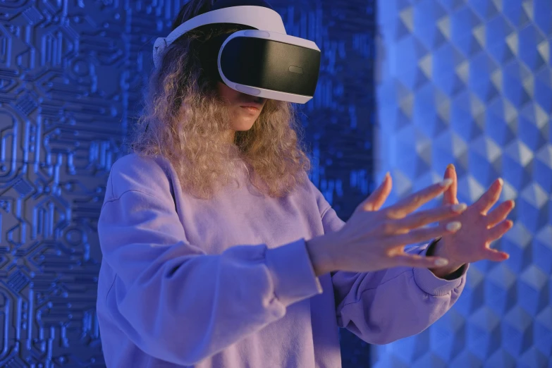 a man with long hair wearing a virtual reality headset, a hologram, by Adam Marczyński, pexels, interactive art, photograph of a techwear woman, waving, siggraph, thumbnail