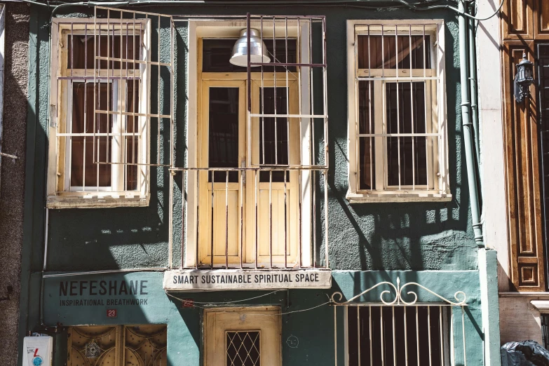 a building with a motorcycle parked in front of it, inspired by Elsa Bleda, unsplash, renaissance, cyan shutters on windows, istanbul, green alley, a steampunk store