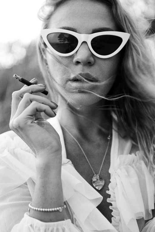 a black and white photo of a woman smoking a cigarette, a black and white photo, inspired by Peter Lindbergh, unsplash, sun glasses, sydney sweeney, wearing white clothes, terry richardson