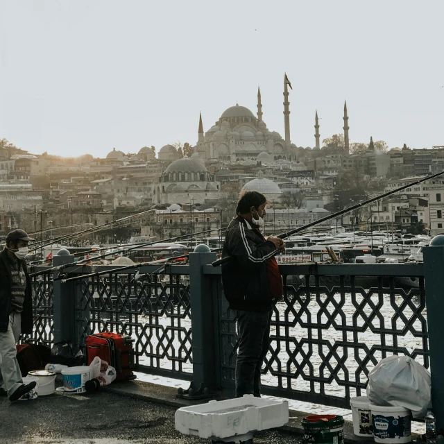 a group of people standing on top of a bridge, by Ismail Acar, pexels contest winner, hurufiyya, fish in the background, fallout style istanbul, fishing, music being played