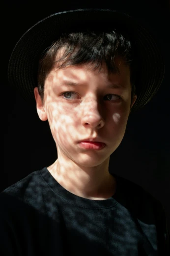 a close up of a person wearing a hat, by Antoni Pitxot, pexels, hyperrealism, light over boy, looking threatening, light ray, young teen