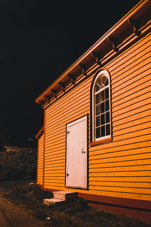 a yellow building sitting on the side of a road, by Carey Morris, pexels contest winner, victorian harbour night, barn, white and orange, crisp lines and color