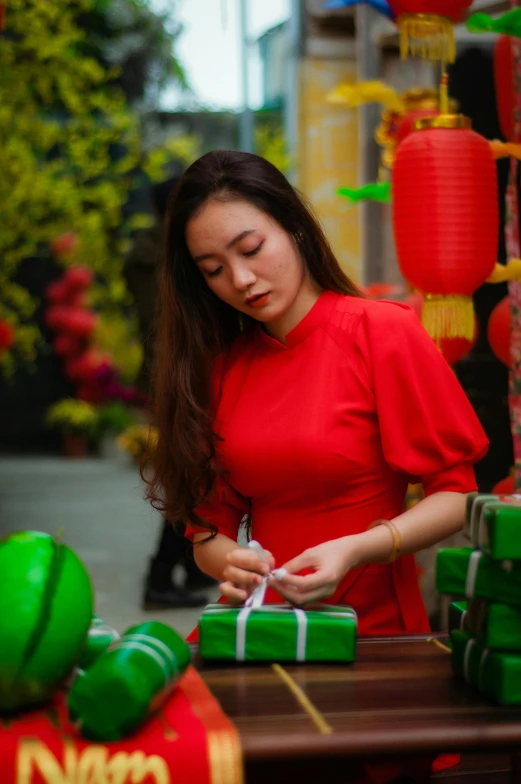 a woman in a red dress signing a gift, pexels contest winner, happening, vietnamese woman, red and green, avatar image, red flags holiday