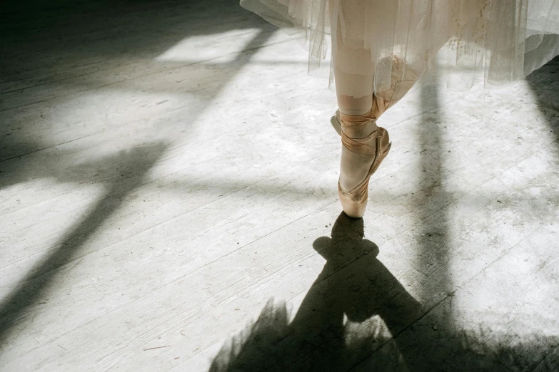 a close up of a ballerina's feet in front of a window, by Elizabeth Polunin, pexels contest winner, arabesque, sunlight shining through, standing in an arena, silver，ivory, long shadow