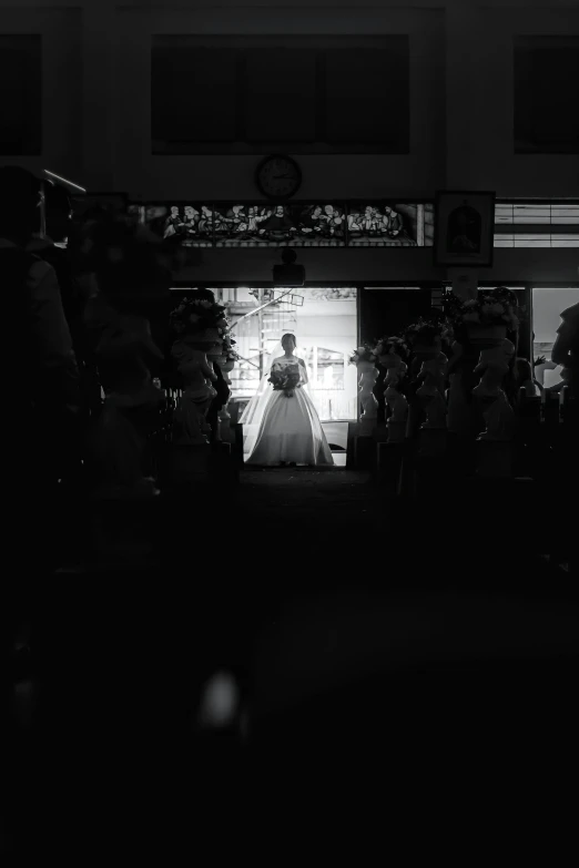 a black and white photo of a bride walking down the aisle, by Basuki Abdullah, unsplash contest winner, in a workshop, dark bright effect, in a mall, single color
