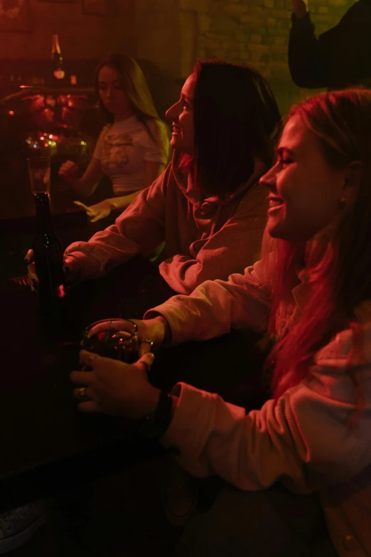 a group of people sitting around a table playing a video game, red lights, bartending, profile image, happy girl