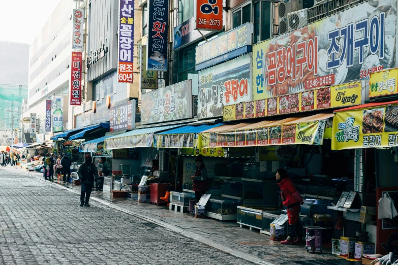 a group of people walking down a street, by Gang Se-hwang, unsplash, graffiti, food stalls, square, quiet beauty, 90s photo