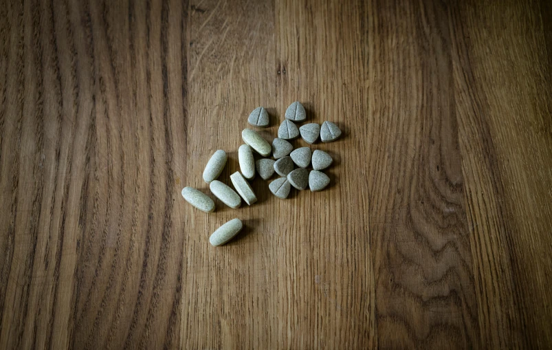 a pile of rocks sitting on top of a wooden table, product image, alien capsules, oak, a high angle shot