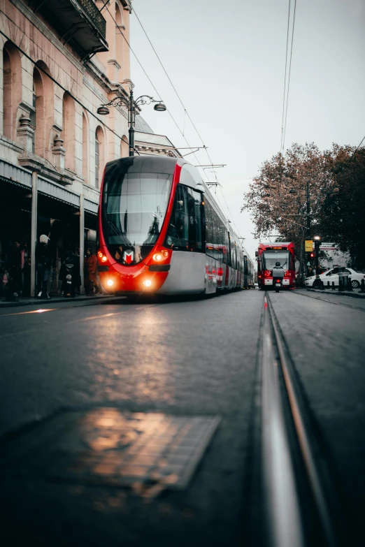 a red and white train traveling down a street, pexels contest winner, grey, trams, in australia, square