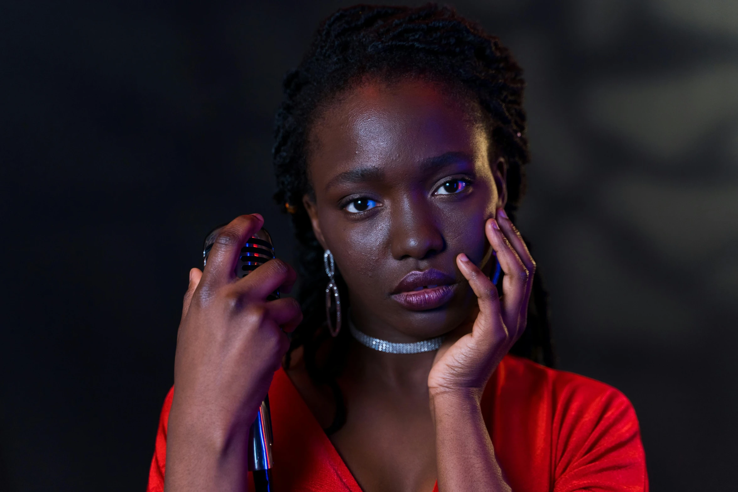 a woman in a red dress talking on a cell phone, pexels contest winner, photorealism, dark black skin tone, looking intensely at the camera, shot at dark with studio lights, adut akech