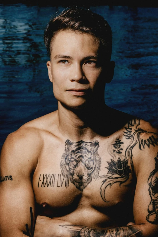 a man with tattoos on his chest and chest, inspired by Nikolaj Abraham Abildgaard, trending on pexels, frank dillane as puck, darren quach, promo photo, tom of finland
