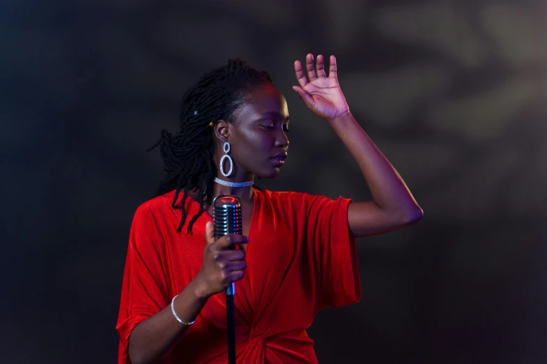 a woman in a red shirt holding a microphone, by Winona Nelson, pexels contest winner, figuration libre, adut akech, standing elegantly, 15081959 21121991 01012000 4k, lights