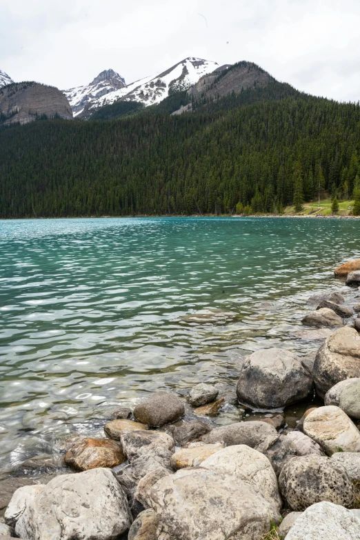 a large body of water with mountains in the background, banff national park, floating stones, shoreline, belle