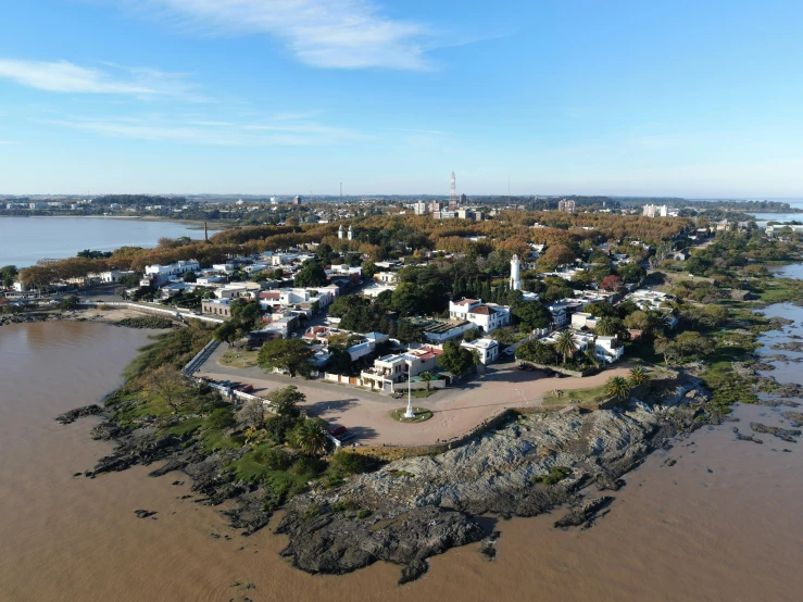 a small island in the middle of a body of water, by Alejandro Obregón, drone view of a city, giraud, buenos aires, looking partly to the left