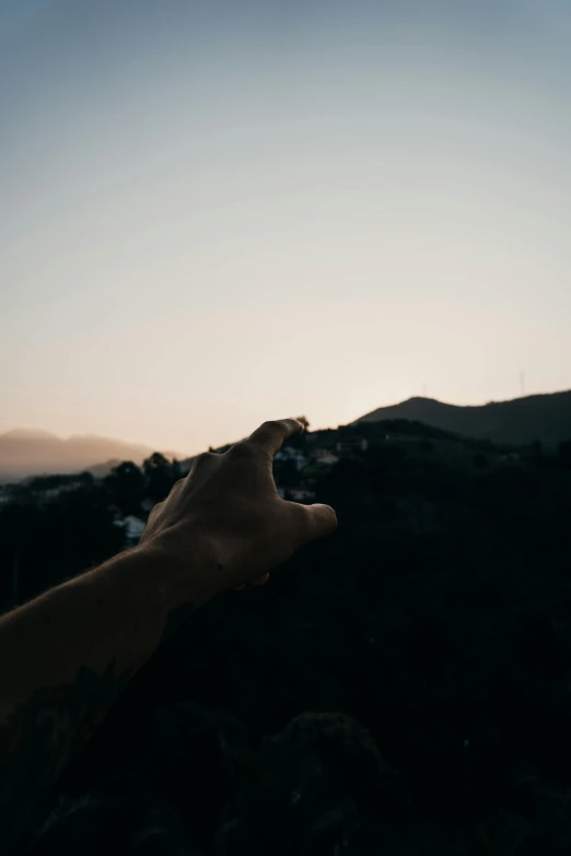 a person holding a cell phone up to the sky, by Alexis Grimou, unsplash, over the hills, close-up of thin soft hand, morning time, pointing at the camera