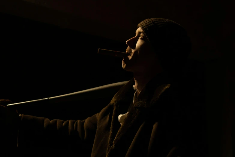 a man is singing into a microphone in the dark, a portrait, by Eglon van der Neer, unsplash, figuration libre, holding a cigar, aiden gillen, high resolution movie still, long night cap