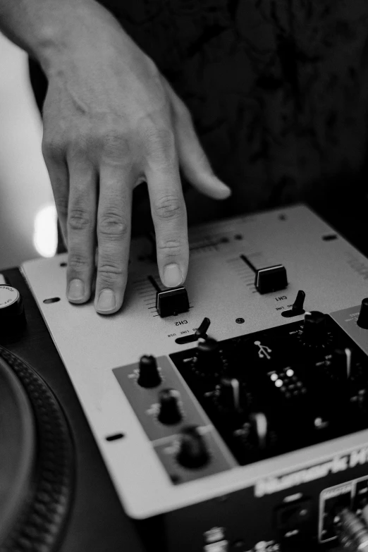 a close up of a person using a dj controller, a black and white photo, uploaded, hand gesture, album cover, instrument