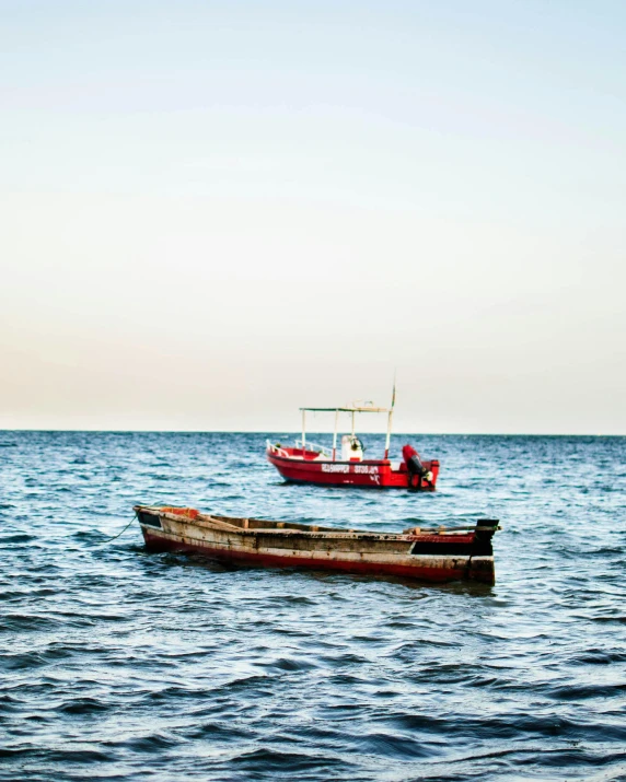 a couple of boats floating on top of a body of water, by Arabella Rankin, pexels contest winner, hurufiyya, nubian, lgbtq, red sea, thumbnail