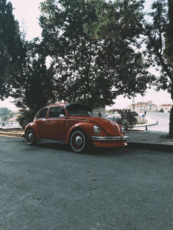 a red car parked on the side of the road, a picture, by Pablo Rey, pexels contest winner, hyperrealism, beetle, trending on vsco, eternal city, brown