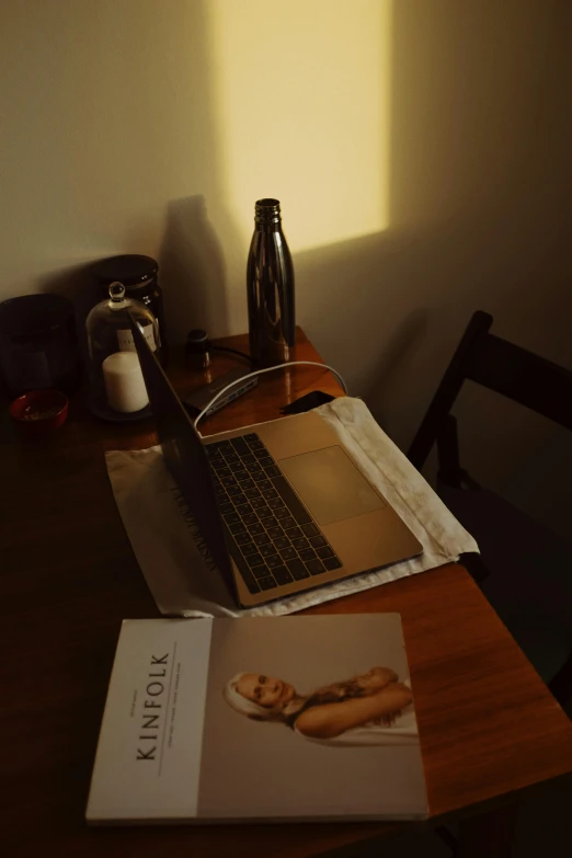 a laptop computer sitting on top of a wooden desk, by Robbie Trevino, light and space, in style of nan goldin, soft lighting |, sitting on a mocha-colored table, sun puddle