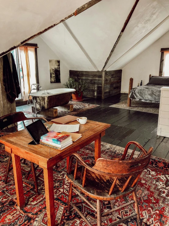 a living room filled with furniture and a wooden table, by Jessie Algie, unsplash, renaissance, in an attic, interior of a tent, top floor boss shit, research outpost