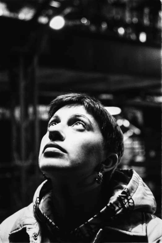 a black and white photo of a man looking up, a black and white photo, inspired by Ruth Deckard, woman in a dark factory, the eyes of sharbat gula, 35mm color lomography, cyborg merchant woman