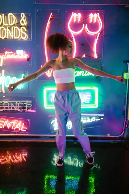 a woman standing in front of a neon sign, inspired by David LaChapelle, trending on pexels, willow smith zendaya, dancefloor, wearing a cropped top, bounce lighting