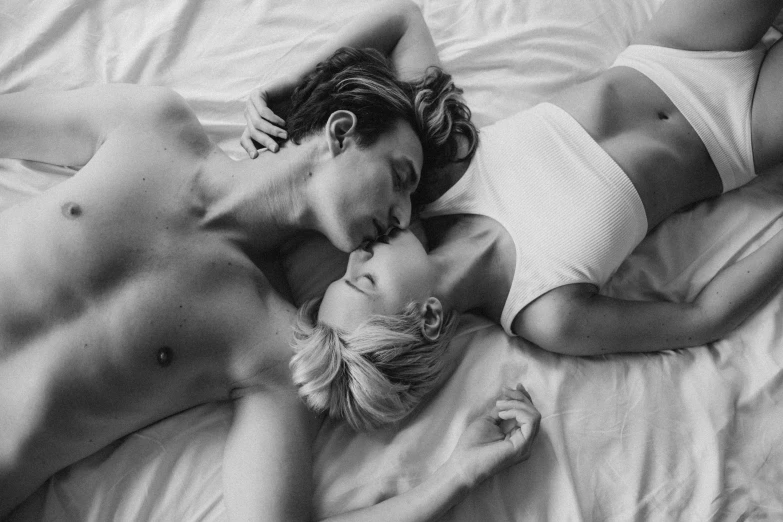 a man and a woman laying on top of a bed, a black and white photo, by Emma Andijewska, pexels, romanticism, kisses are wordless spells, 🌸 🌼 💮, casey cooke, joel fletcher