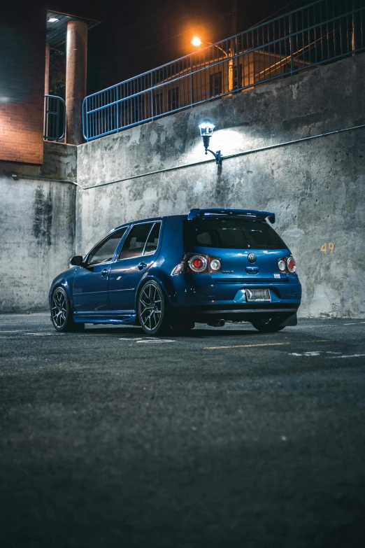 a blue car parked in a parking lot at night, 🚿🗝📝, on the concrete ground, wrx golf, unsplash contest winning photo