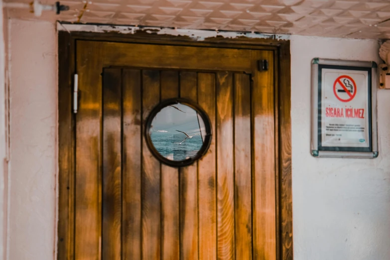a wooden door with a round mirror on it, pexels contest winner, on a boat, smooth panelling, 3 4 5 3 1, under repairs