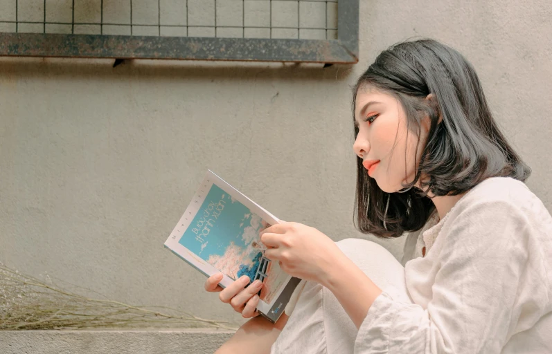 a woman sitting on the ground reading a book, inspired by Kim Du-ryang, pexels contest winner, avatar image, side view, half body photo, background image