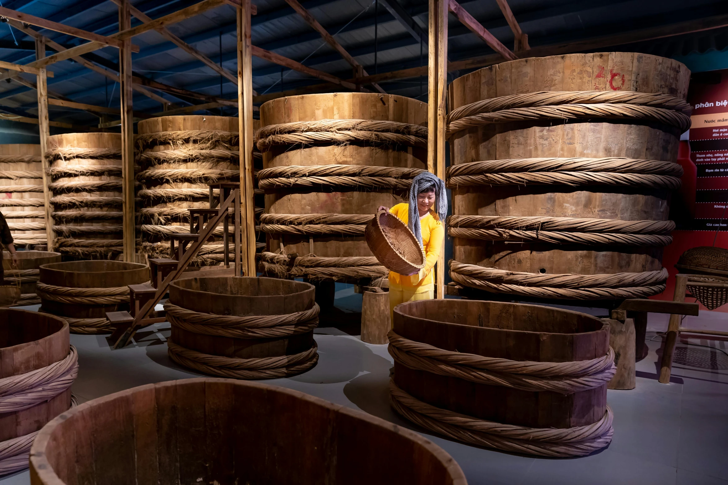 a room filled with lots of wooden barrels, inspired by Li Di, cai xukun, a person standing in front of a, bowl, documentary photo