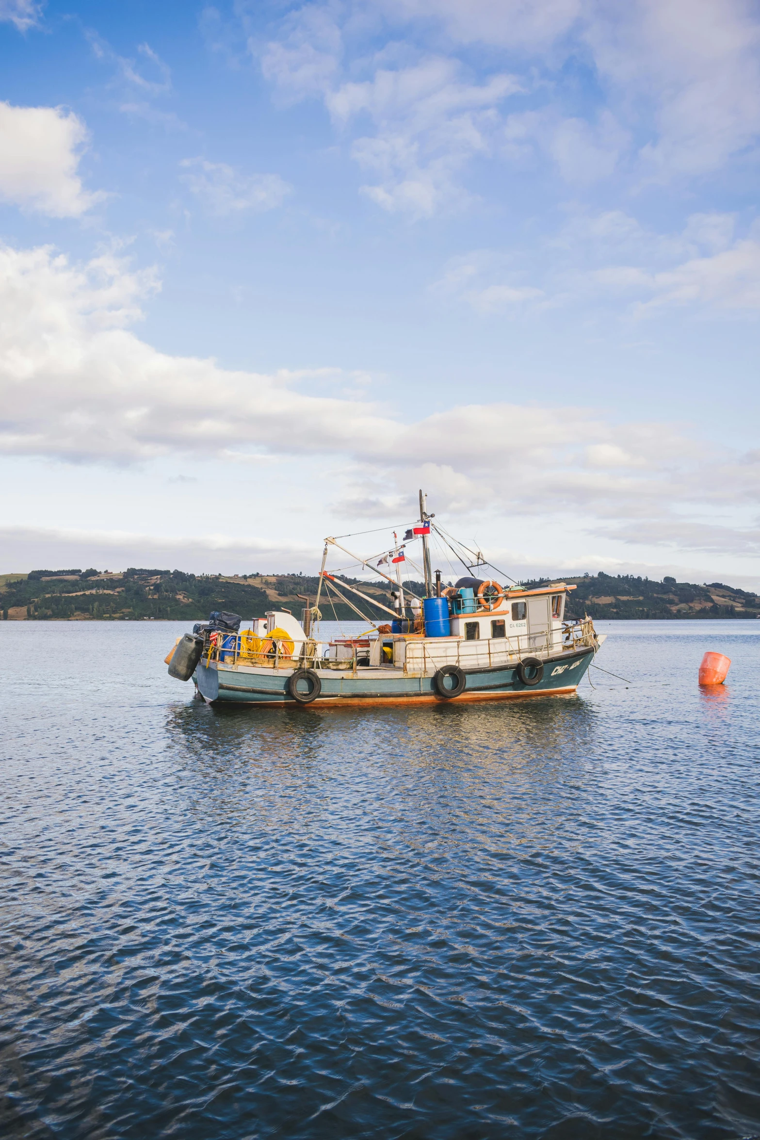 a boat floating on top of a body of water, by David Paton, pexels contest winner, wellington, fish seafood markets, mustard, mid morning lighting