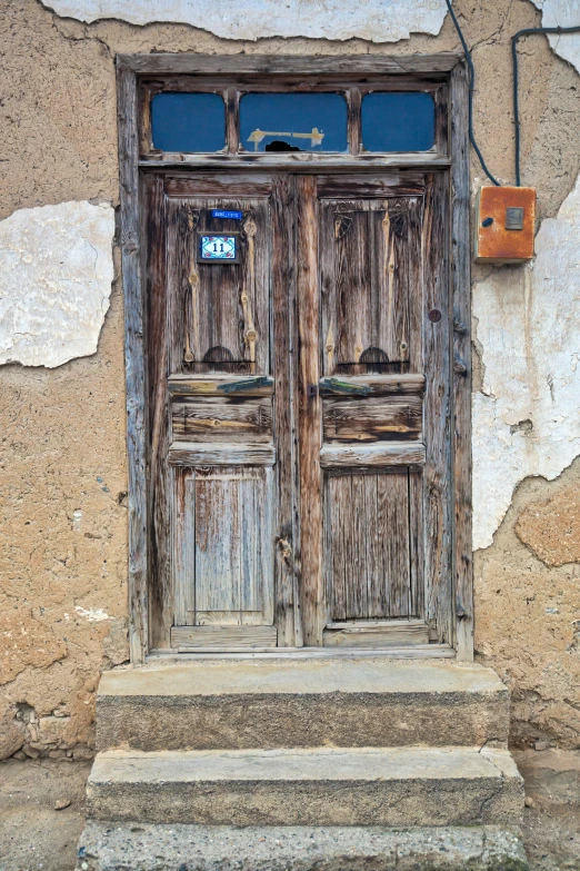 a wooden door sitting on the side of a building, les nabis, ((rust)), in chuquicamata, photographs, square