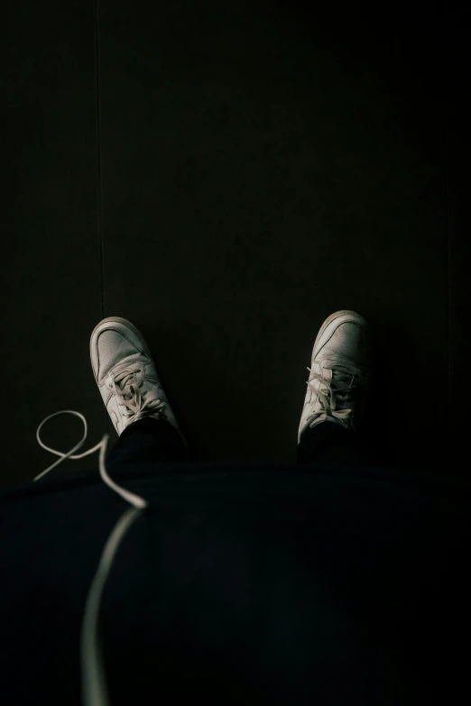 a pair of white sneakers sitting on top of a black floor, unsplash, rope, scary, single portrait, wearing a track suit