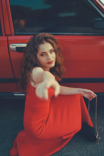 a woman in a red dress sitting in front of a red car, an album cover, by Winona Nelson, pexels contest winner, renaissance, reddish hair, asher duran, square, looking this way
