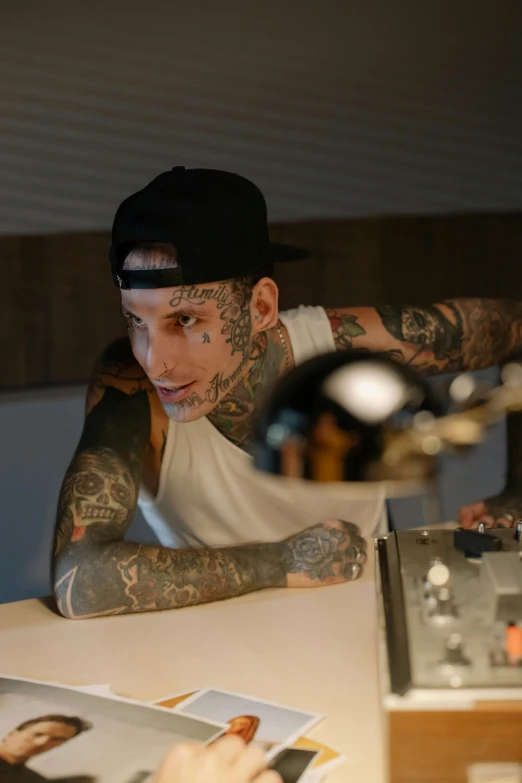 a man that is sitting at a table, a tattoo, inspired by Seb McKinnon, aussie baristas, djing with dj turntables, profile image, chef table