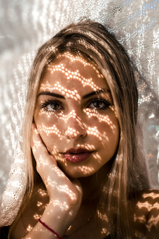 a woman that is standing in front of a curtain, a stipple, trending on pexels, light and space, backlit beautiful face, kaleidoscopic, sunbathed skin, young blonde woman