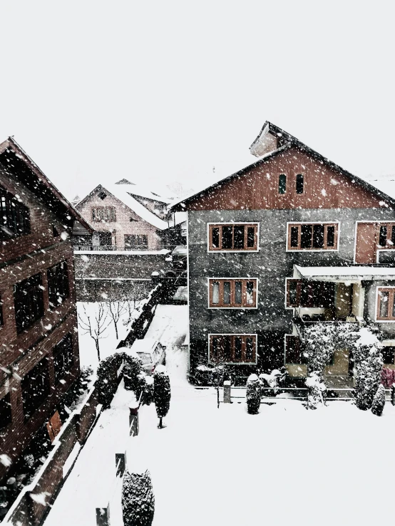 a group of people walking down a snow covered street, pexels contest winner, hurufiyya, wooden houses, view from window, 💋 💄 👠 👗, during snowfall