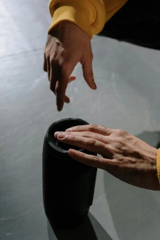 a person touching a black object on a table, o'neill cylinder, tai chi, promo image, fluid and dynamic forms