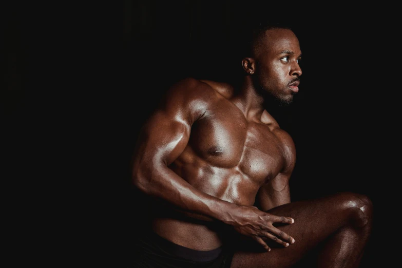 a man sitting on a stool in the dark, inspired by Terrell James, pexels contest winner, les nabis, beautiful muscular body, ebony skin, 30 year old man :: athletic, body building blacksmith