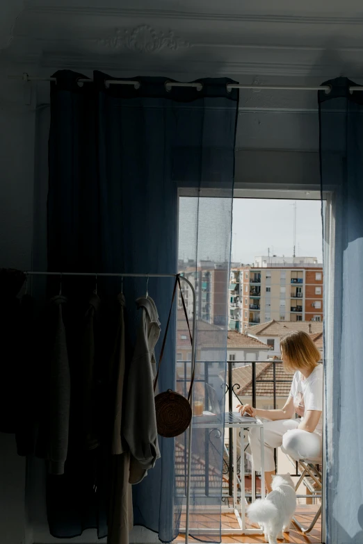 a woman sitting on a chair in front of a window, in barcelona, someone in home sits in bed, 2019 trending photo, gif